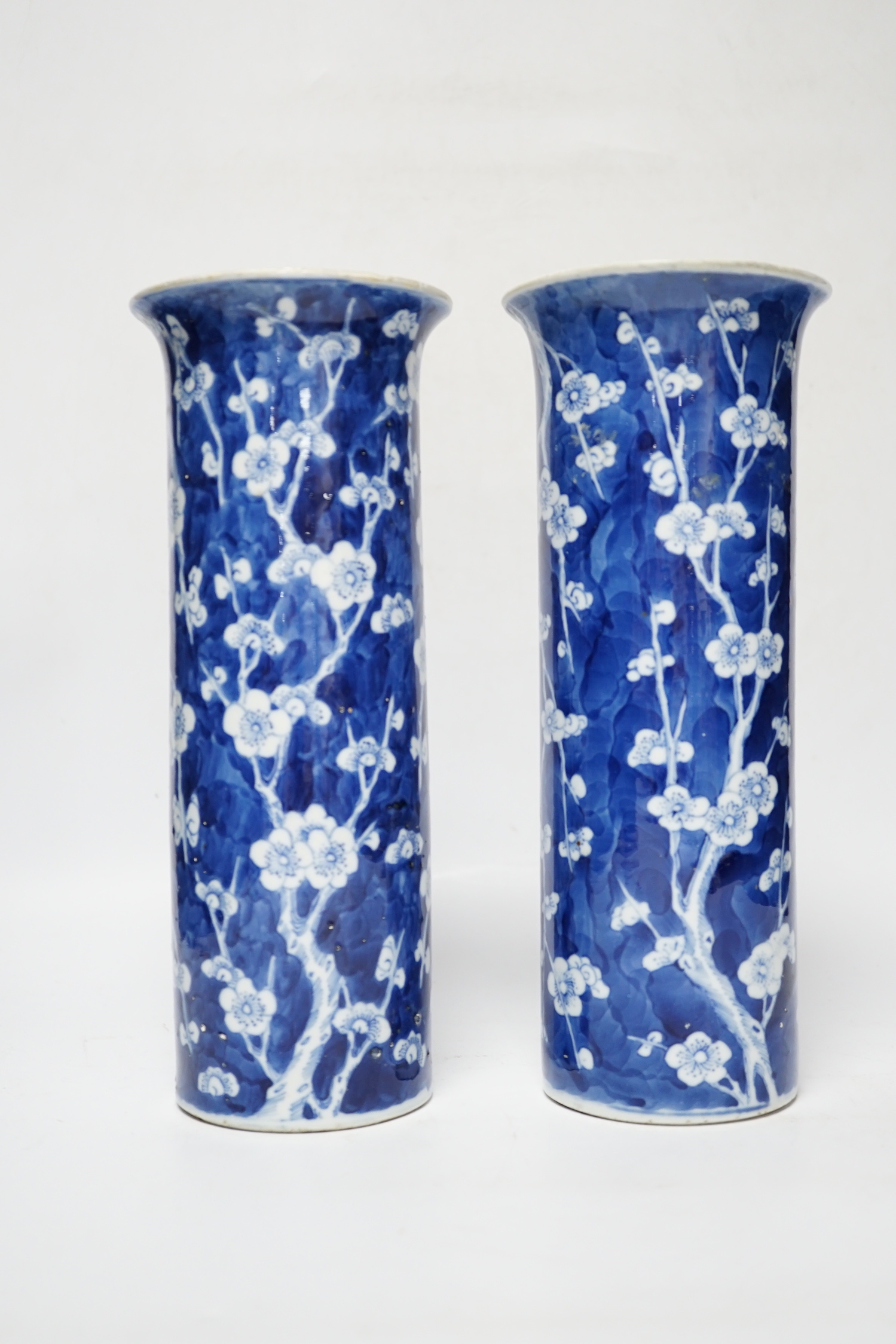 A pair of Chinese blue and white prunus flower sleeve vases, c.1900, (restored), 26cm high